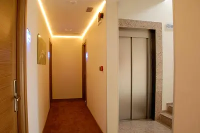 a hallway with white walls and a hallway with a door at Lounge Hotel in Tuzla