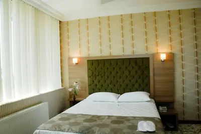 a bedroom with a large bed with two pillows at Lounge Hotel in Tuzla