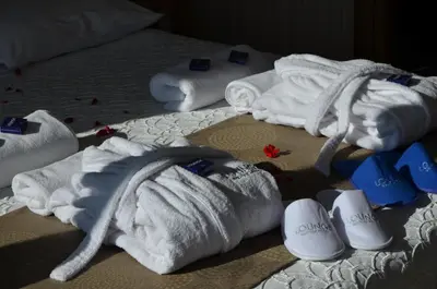 a group of towels andippers on a bed at Lounge Hotel in Tuzla