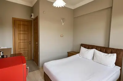 a bedroom with a white bed and a red chair at Biter Hotel in Istanbul