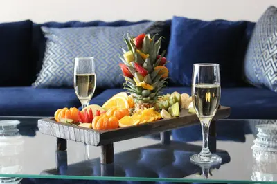 a tray of fruit on a table with two glasses of wine at Quars Suite in Esenyurt