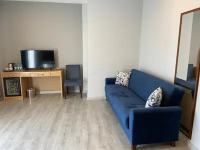 a living room with a blue couch and a tv at Liberi Hotel Taksim in Istanbul