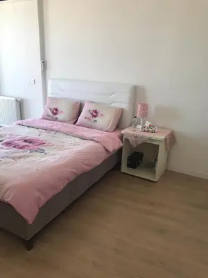 a bedroom with a bed with pink sheets and a table at Have a nice holiday in Istanbul