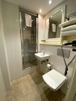 a white bathroom with a sink and a shower at Meroddi Galata Flats in Istanbul