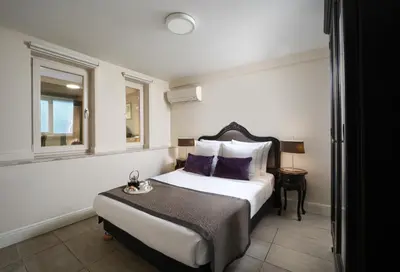 a hotel room with a bed with purple pillows at Meroddi Galata Flats in Istanbul