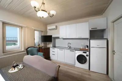 a kitchen with white cabinets and a table and a sink at Meroddi Galata Flats in Istanbul