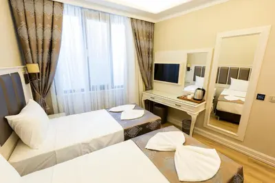 a hotel room with two beds and a mirror at Villa Sweet Hotel in Istanbul