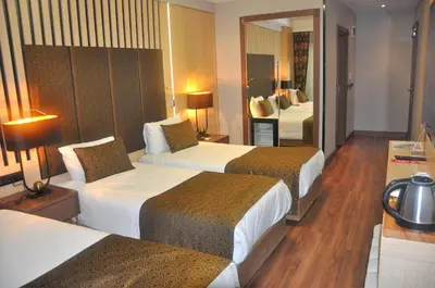 a hotel room with two beds and a mirror at Pell Palace Hotel & SPA in Istanbul