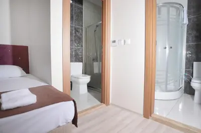 a bedroom with a bed and a bathroom with a toilet at BEKSİTİ HOTEL in Yalova