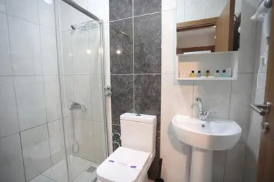 a bathroom with a shower and a toilet and a sink at BEKSİTİ HOTEL in Yalova