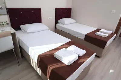 a small room with two beds and a desk at BEKSİTİ HOTEL in Yalova
