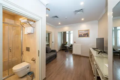 a bathroom with a toilet and a couch in a room at Almadina Hotel Istanbul in Istanbul