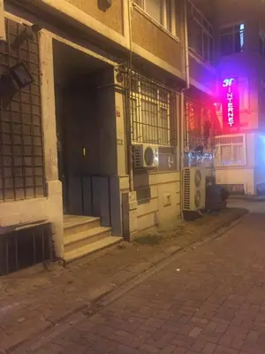 an empty street in front of a building at night at Çatı Apartment in Istanbul