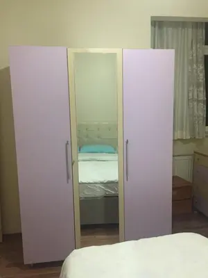 a bedroom with two white cabinets and a bed at Eda's Apartment in Istanbul