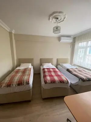 two beds in a small room with a table at Yakup's Apartment in Istanbul