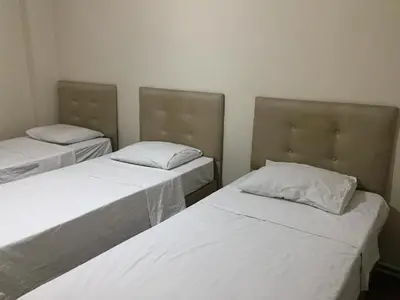 two beds in a room with white sheets and pillows at Yakup's Apartment in Istanbul