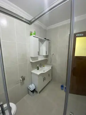 a white bathroom with a sink and a shower at Yakup's Apartment in Istanbul