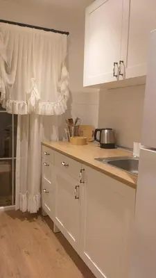 a kitchen with white cabinets and a sink and a window at The White Swan Suites Beyoglu in Istanbul