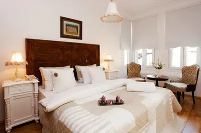 a white bedroom with a large bed with shoes on it at The White Swan Suites Beyoglu in Istanbul