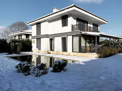 a house in the snow with a pond in front at Bahar Villas Sapanca in Sapanca