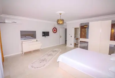 a white bedroom with a bed and a tv at Bahar Villas Sapanca in Sapanca
