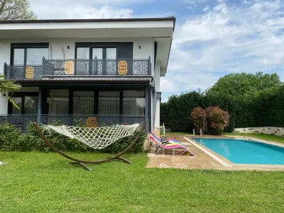 a house with a hammock next to a swimming pool at Bahar Villas Sapanca in Sapanca