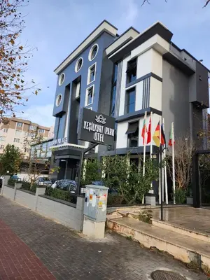 a building with a sign for a hotel with flags at Yeşilyurt Park Otel in Corlu