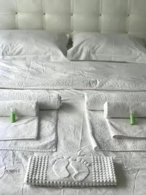 a bed with white sheets and towels on it at Rodos HAN in Istanbul