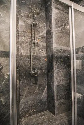 a shower in a bathroom with a stone wall at LUXIR HOTEL in Istanbul