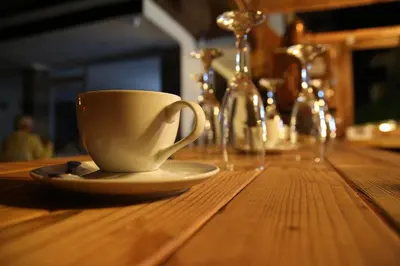 a white coffee cup sitting on a wooden table at Beach Butik Hotel Şile in Istanbul