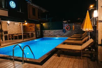 a swimming pool at night with a table and chairs at Beach Butik Hotel Şile in Istanbul