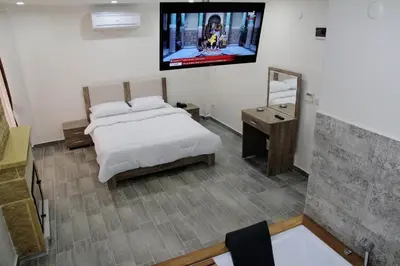 a bedroom with a bed and a tv on the wall at Beach Butik Hotel Şile in Istanbul