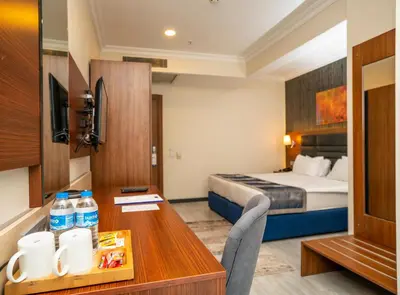 a hotel room with a bed and a desk with a table sidx sidx at The Bostancı Otel in Istanbul