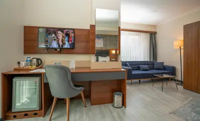 a living room with a desk with a tv and a couch at The Bostancı Otel in Istanbul