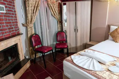 a bedroom with two chairs and a bed and a fireplace at Ağva Carpediem Otel in Agva