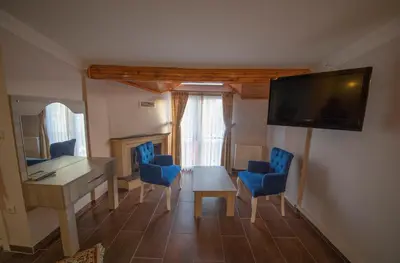 a living room with a table and chairs and a television at Ağva Carpediem Otel in Agva