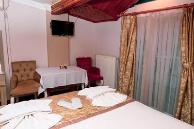 a hotel room with two beds and a table and chairs at Ağva Carpediem Otel in Agva