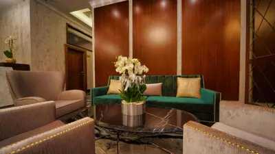 a living room with a green couch and a table with flowers at My Dream Istanbul Hotel in Istanbul