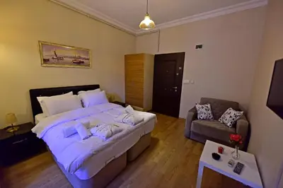a bedroom with a large bed and a couch at Sunshine Taksim Suite in Istanbul