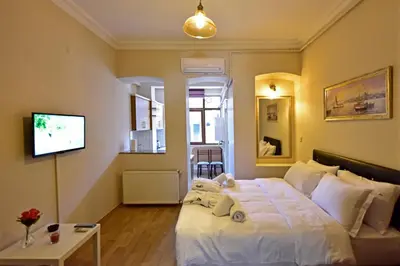 a bedroom with a white bed and a television at Sunshine Taksim Suite in Istanbul