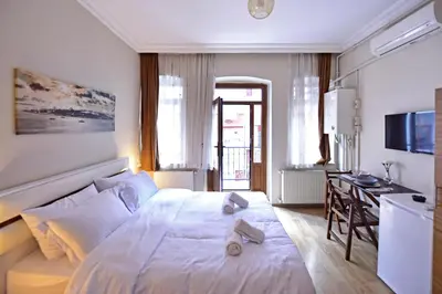 a bedroom with a large white bed and a desk at Sunshine Taksim Suite in Istanbul