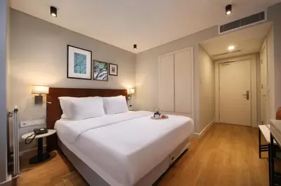 a bedroom with a large white bed and a door at Suadhan Hotel in Istanbul