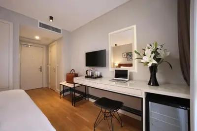 a bedroom with a desk with a laptop and a vase of flowers at Suadhan Hotel in Istanbul