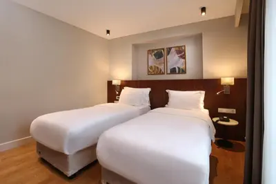 two beds in a hotel room with white sheets at Suadhan Hotel in Istanbul