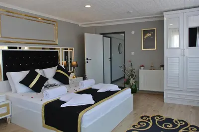 a bedroom with a large white bed with black and white pillows at Emirhan Guesthouse & Suites in Istanbul