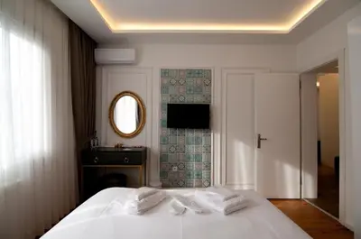 a bedroom with a bed with white sheets and a mirror at Blue Mosque Suites 2 - Old City Sultanahmet in Istanbul