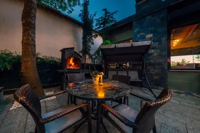 a table and chairs with a fireplace in a patio at antik river house in Sile