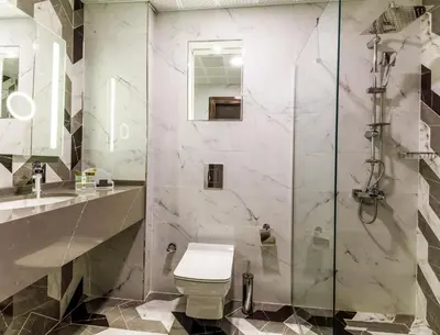 a bathroom with a toilet and a glass shower at Euro Design Hotel in Istanbul