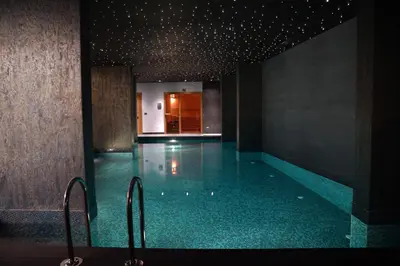 a swimming pool with a blue tile floor and stairs at Galata's Hotel in Istanbul