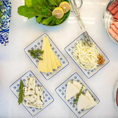 a table topped with plates of cheese and vegetables at Galata's Hotel in Istanbul